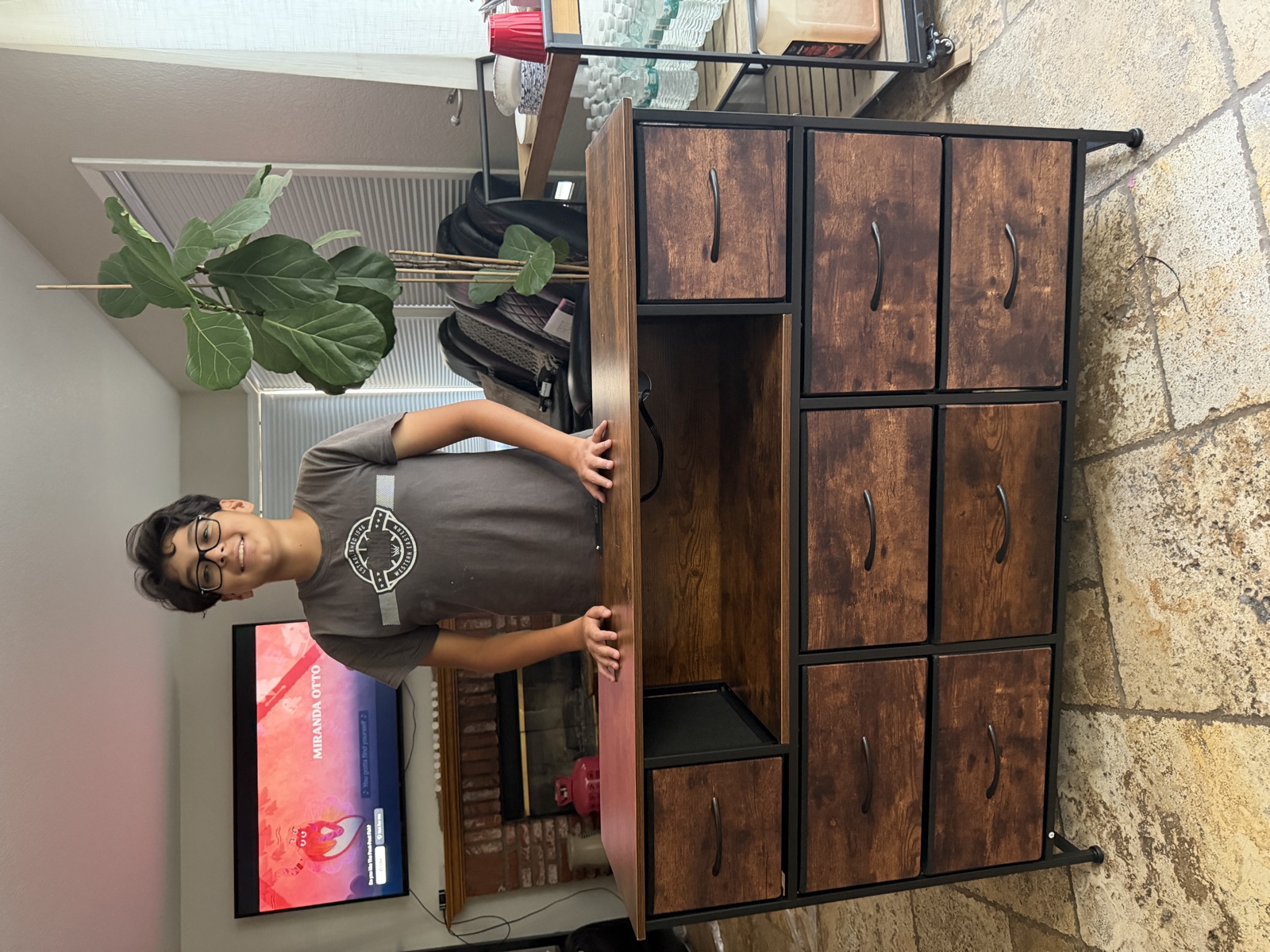 A student standing behind a completed furniture project